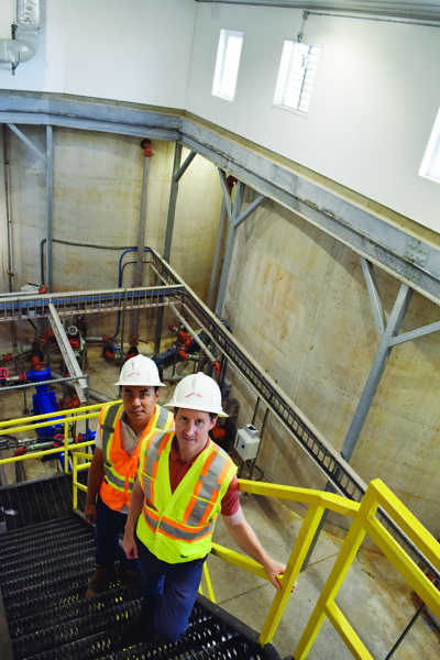 Sam Huang (left), biodigester general manager, and Andrew Mauchlen, manager of organics, in the stairwell leading down to the inner workings of the biodigester tanks - seen in the background - which go 20 feet into the ground.