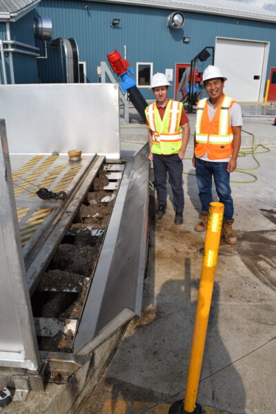 Andrew Mauchlen, left, and Sam Huang at the above-ground cover of one of the 400 cubic metre capacity disgester tanks.